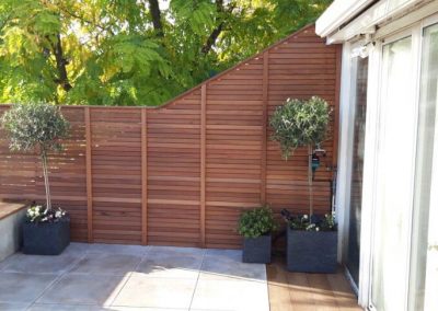 Wooden fencing on outdoor patio with two plants