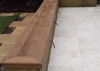 low wooden wall separating patio from garden