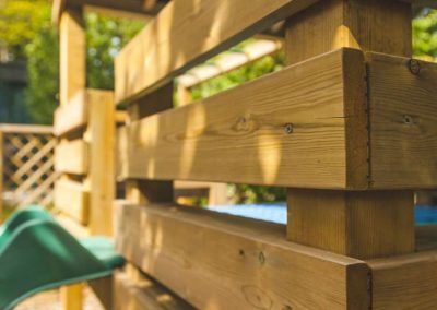 close up of wooden play platform with green slide for children