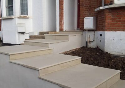 large cream steps leading from pavement to house